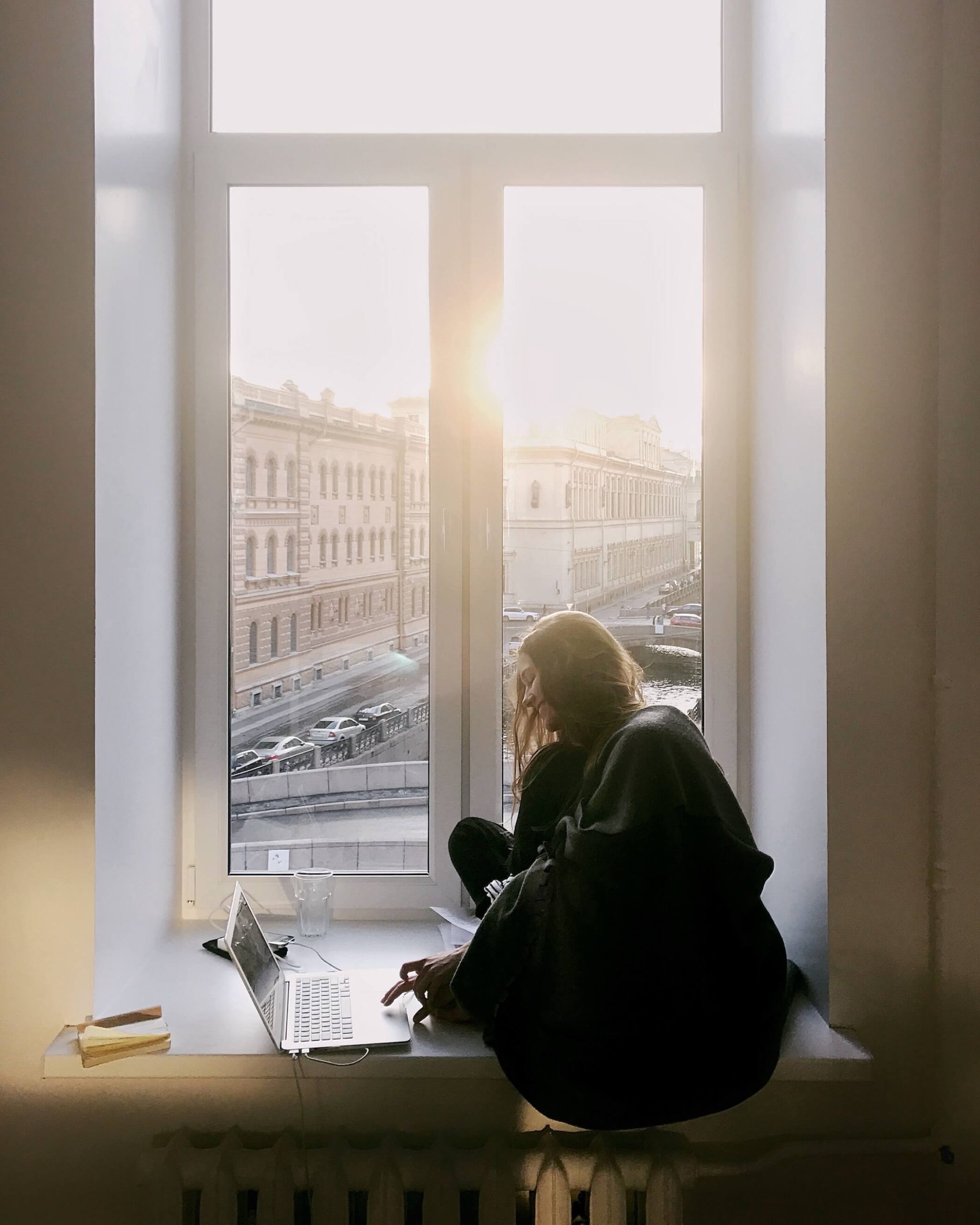 woman in black sitting in bay window